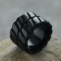 Detail eines breiten schwarzen Edelstahlrings mit einer geprägten 3D Reifenprofil-Textur - Schwarz