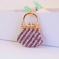 Golden purse keychain with purple and white rhinestones on a clean white surface - Purple