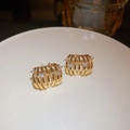 Boucles d'oreilles créoles dorées multicouches avec zircons blancs sur plateau - Cage creuse multicouche dorée