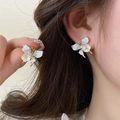 Elegant gold butterfly earrings with blue gradient wings and white floral accents on model - 39# Gold Blue Gradient Butterfly Flower Earrings