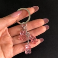 Detailed close-up of three pink translucent jelly bear charms on a metal keychain - Pink