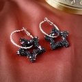 Detail van zilveren oorringen met zwarte sterhangers en roze glinsterende strass-steentjes - Zwarte Ster Zilveren Ring