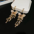Vue détaillée de boucles d'oreilles papillon dorées avec cristaux sur velours noir - 45# Tige en Argent - Or - Rose