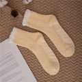 Detail showing non-slip silicone grippers on yellow coral fleece slipper socks for women - One Size / Light Yellow with Grippers