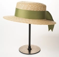 Detail of a natural straw boater hat featuring an olive green ribbon and elegant bow - 7cm Green Ribbon