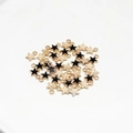 DIY star pendants with black drip oil and gold finish scattered on white surface - Black Star