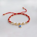 Dettaglio del bracciale occhio del male rosso con perle naturali e tocchi dorati - Stile Perla Malocchio con Filo Rosso