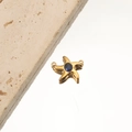 Close-up of golden starfish pendant with a blue gemstone on a neutral stone background - 5# Starfish Blue Zircon