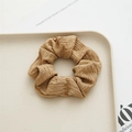 Minimalist beige scrunchie with pleated fabric texture on a decorative tray - Khaki