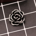 Detalle macro de un broche de camelia negra vintage con brillantes strass en los pétalos - Camelia de Diamantes de Imitación-Plata