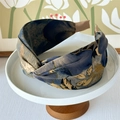 Detail showing the floral fabric texture and brown ribbed ends of a wide knotted headband - Blue Floral Print