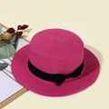 Dettaglio di un cappello di paglia fucsia con fiocco nero per l'abbigliamento estivo da mare - Bambini (53-55CM) / Rosa Rossa