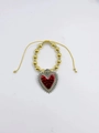 Vue détaillée d'un charm cœur rouge gothique sur un bracelet de perles or et argent. - Sacré-Cœur Couronné à l'Huile Rouge (D)