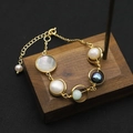Gold-plated pearl bracelet with natural shell and colorful stones on a vintage wooden block - Shell Five Circle Bracelet