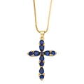 Dettaglio di una collana a catena dorata con pendente a croce in zircone blu su fondo bianco - Blu