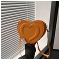 Détail d'un sac à bandoulière orange en forme de cœur avec texture gaufrée chic - Orange
