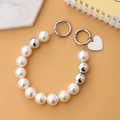 Catena di perle e sfere di metallo con ciondolo a cuore e fibbie a molla su marmo - Catena da Mano Perla e Argento (K844)