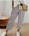 Detailed close-up of striped loose trousers with elastic waist and straw textured handbag - S / Bottoms / Gray