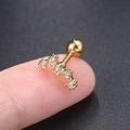 Detailed macro view showing a gold-plated curved ear stud with five inlaid zircons on a finger - Big Dipper Gold - 1PC
