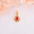 Macro d'un pendentif goutte doré avec pierre rouge poire et petits cristaux brillants - Or avec zircone rouge