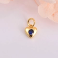 Detail eines goldenen Herzanhängers mit einem tiefblauen Zirkonia und einer Aufhängung - Dunkelblauer Zirkonia