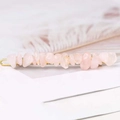 Macro shot of pink natural crystal stones set on a golden metal hair clip base - Rose Quartz + Gold Clip