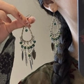 Detail of bohemian tassel earrings featuring green beads and metal feather charms on model - 4# Hook-Antique Silver-Green Tassel