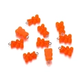 Macro shot of nine orange transparent resin bear charms with eyelet screws for DIY jewelry - Orange
