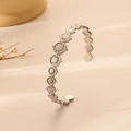 Detail of silver open bangle with continuous circular sun patterns and metallic luster - Silver Sun Disc