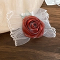 Détail macro d'un accessoire rose en dentelle rouge avec des pétales en tulle délicat - Marron