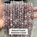 Natural purple Auralite crystal round beads bracelet held against a street background - Natural Auralite Amethyst Crystal / 10mm approx 37pcs