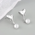 Macro shot of silver lava textured heart earrings with zircons and white pearl drops - Liquid Artificial Pearl Stud Silver