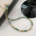 Tiger eye beaded necklace with colorful round stones and gold spacers on marble surface - Light Agate Slices Necklace XL0690