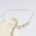 Dettaglio del cerchietto dorato con perle finte bianche e stella di strass su vassoio - Cerchietto con Stella di Perle