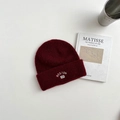 Dettaglio del berretto in lana rosso scuro con ricamo bianco BOSTON 23 in stile retrò - 3-8 Anni / Borgogna