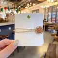 Elegant gold hair clip with white pearls and amber rhinestones on a display card - Amber Rhinestone Pearl Hairpin