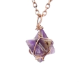 Makro-Detail des handgewebten Kupferdrahtes an einem lila sternförmigen Natursteinanhänger - Antik-Kupfer + Amethyst