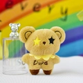 Vue de face d'un mignon ours en peluche marron avec yeux étoiles et col festonné jaune - 12cm / Beige