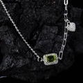 Macro shot of silver emerald green gemstone necklace with asymmetric heart link chain - White Gold Plated Natural Peridot