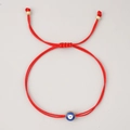 Red braided rope bracelet featuring a blue Evil Eye bead with gold trim and adjustable knot - Red String Edged Blue Eye (JS-B23112005B)