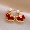Detail of red rocking horse earring with zircon, pearl, and gold wings on beige fabric - 12# Silver Pin - Zircon Pearl Enamel Pony (Real Gold Plated)