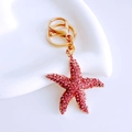 Detailed view of pink rhinestone starfish keychain with gold lobster clasp on white base - Basic Starfish / Light Pink