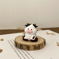 Dettaglio macro di una statuetta di mucca in legno intagliata a mano su base di legno - Mucca