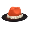 Dettaglio di un cappello fedora in lana bicolore con eleganti file di perle bianche - Arancione + Nero