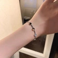 Detail shot of a silver polished snake chain bracelet with round discs on a female wrist - 8-Disc Bracelet-Steel