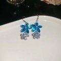 Macro di orecchini a fiore in argento con zirconi blu e bianchi su vassoio ceramico - Orecchini a gancio con fiori / Argento-Blu