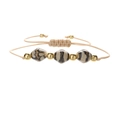 Nahaufnahme von beigem gewebtem Armband mit Goldperlen und facettierten Keramikperlen - Goldperlen + Ultramarin
