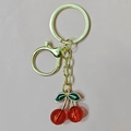 Detail of red cherry resin pendant with green leaf and golden metal keyring clasp - Gold Lobster Clasp Red Cherry (Two Leaves)