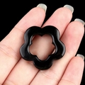 30mm black natural crystal hollow flower pendant accessory displayed on a finger - Obsidian