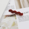 Burgundy acetate wavy hair clip with gold metal base on elegant white background card - Burgundy